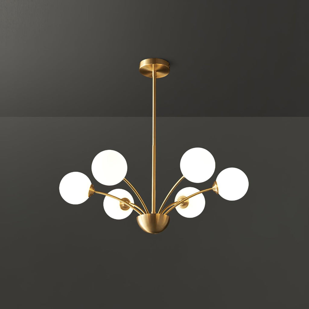 A Clérachic chandelier with six white globes on a brass rod, shown against a dark grey studio backdrop.