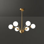 A Clérachic chandelier with six white globes on a brass rod, shown against a dark grey studio backdrop.