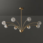 A Clérachic brass chandelier with smoky grey-tinted textured globes, unlit, against a dark grey backdrop.