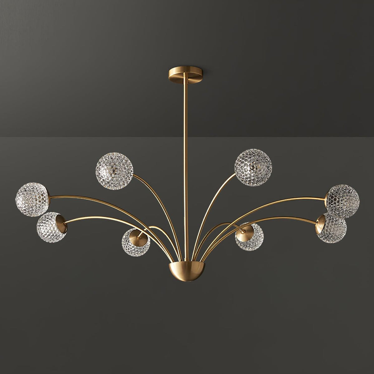 A Clérachic brass chandelier with smoky grey-tinted textured globes, unlit, against a dark grey backdrop.