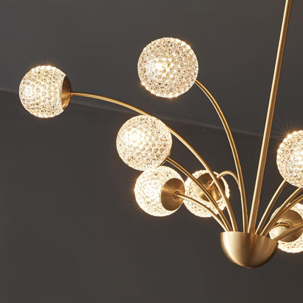Looking up at the lit textured globes and the half-dome brass hub of this Clérachic chandelier against a dark ceiling.