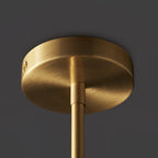 Close view of the round brushed brass ceiling canopy and rod of this Clérachic chandelier against a dark backdrop.