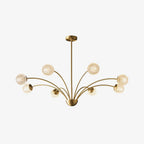 This Clérachic brass chandelier on a plain white backdrop, with textured globes held out on thin curving arms from a half-dome hub.