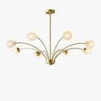 This Clérachic brass chandelier shown whole on a plain pale backdrop, with a slim central rod and eight textured globes on curved arms.