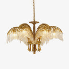 Gold brass palm-leaf chandelier from Clérachic on a plain white backdrop, with clear crystal drops hanging from each leaf.