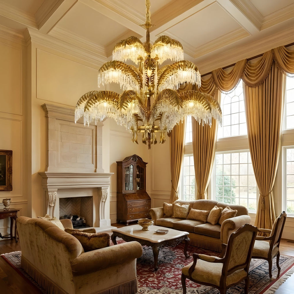 Gold brass leaves glow warmly on this Clérachic chandelier, hung in a double-height living room with gold curtains and a stone fireplace.