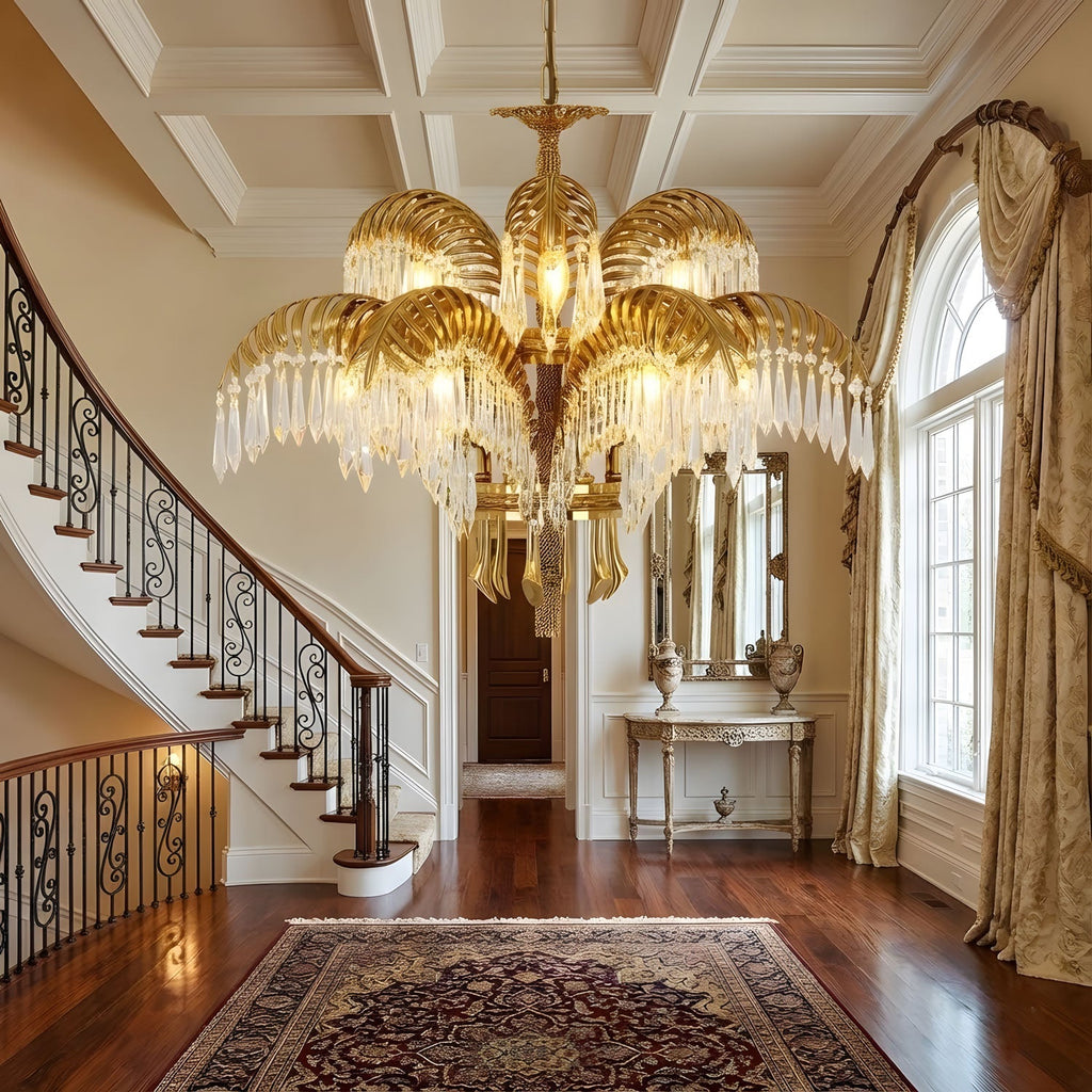 Seen from the hall, a Clérachic brass chandelier hangs beside a curved staircase with a wrought-iron balustrade.