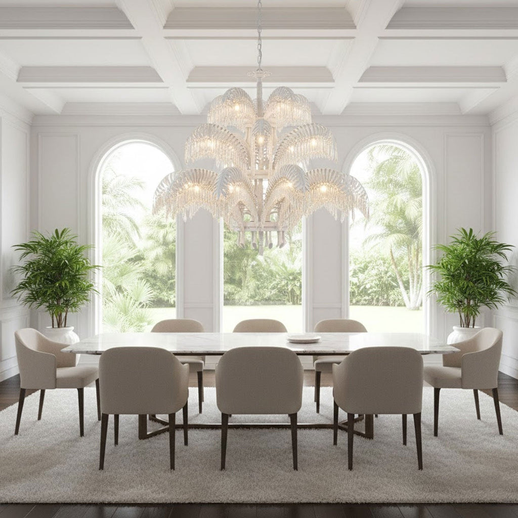 A pale, white-toned Clérachic chandelier hangs in a bright room with three arched windows and a long table with cream chairs.