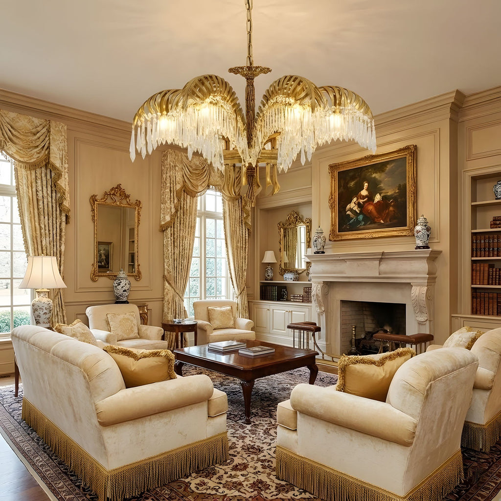 Warmly lit brass leaves of a Clérachic chandelier hang over a cream sitting room with a fireplace and a framed painting.