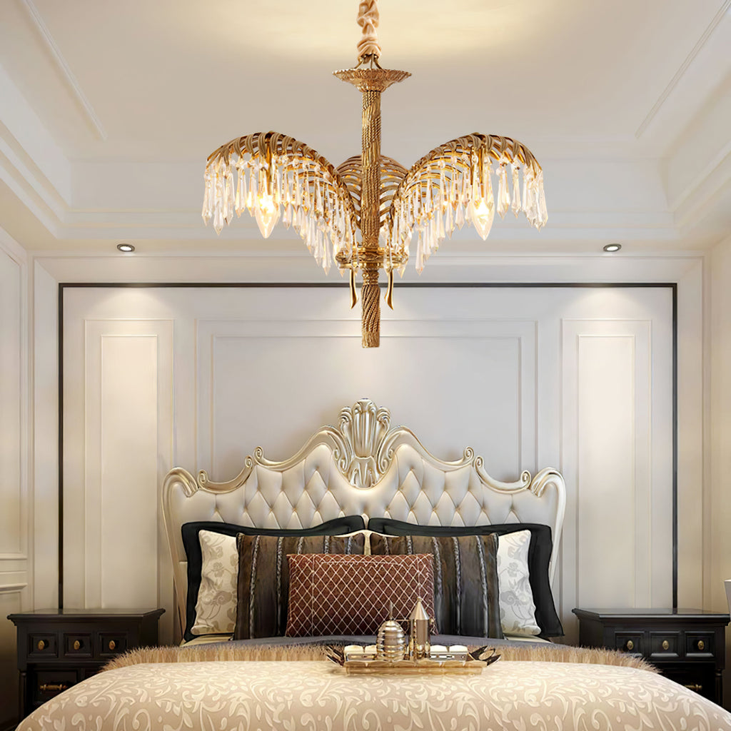 Above a tufted cream headboard in a panelled bedroom, a Clérachic chandelier shows its brass stem and crystal-fringed leaves.