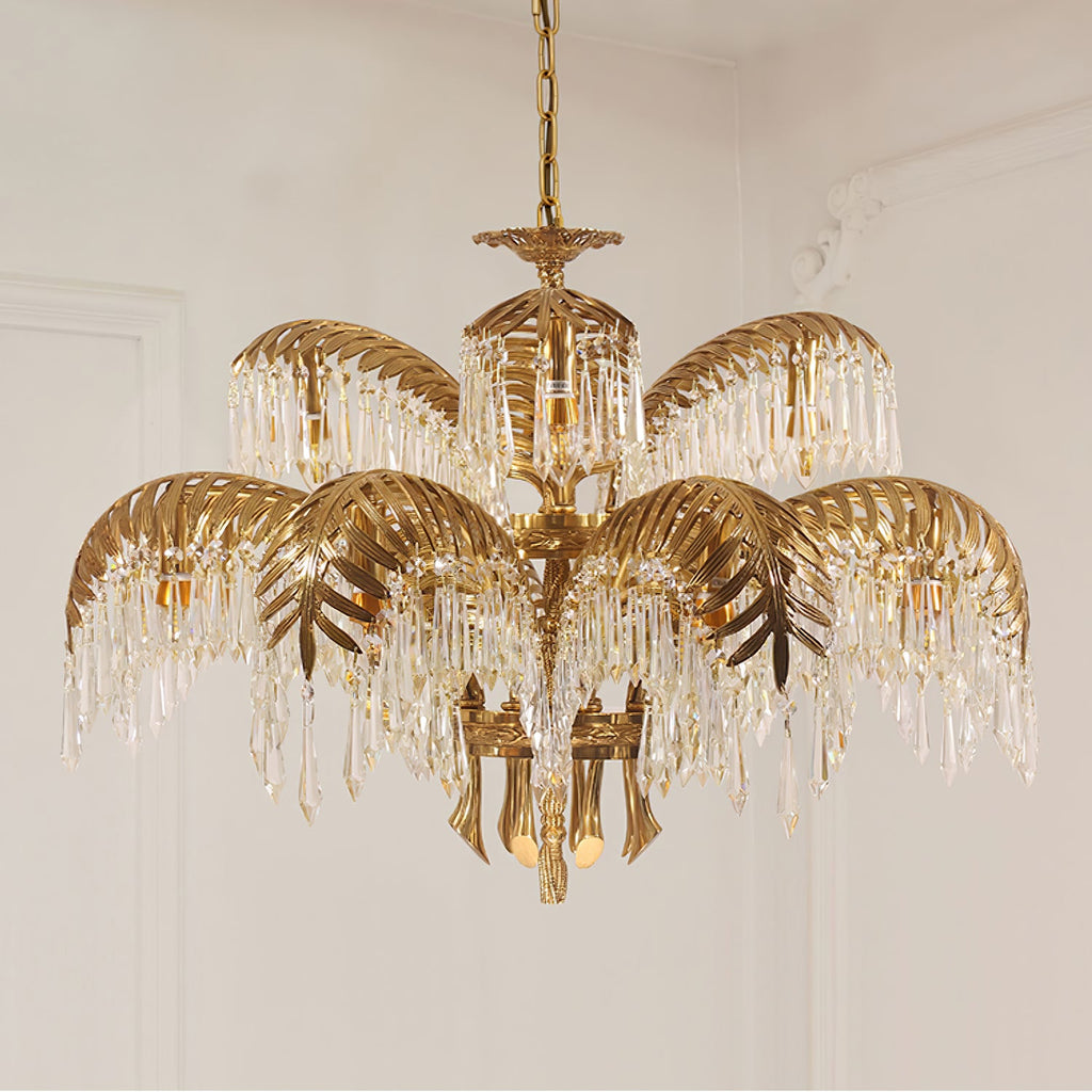 Larger tiered Clérachic chandelier in gold brass, with leaf-shaped tiers and long crystal drops against a pale panelled wall.