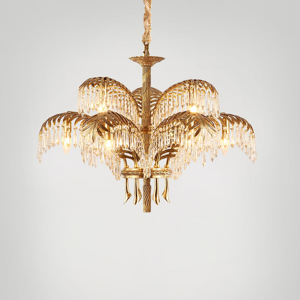 Gold brass Clérachic chandelier with a chain suspension, photographed on a light grey backdrop with its crystal fringes lit.