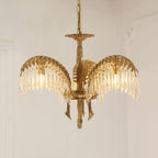 A three-leaf Clérachic chandelier in aged brass on a gold chain, with crystal drops and curved brass tails below.