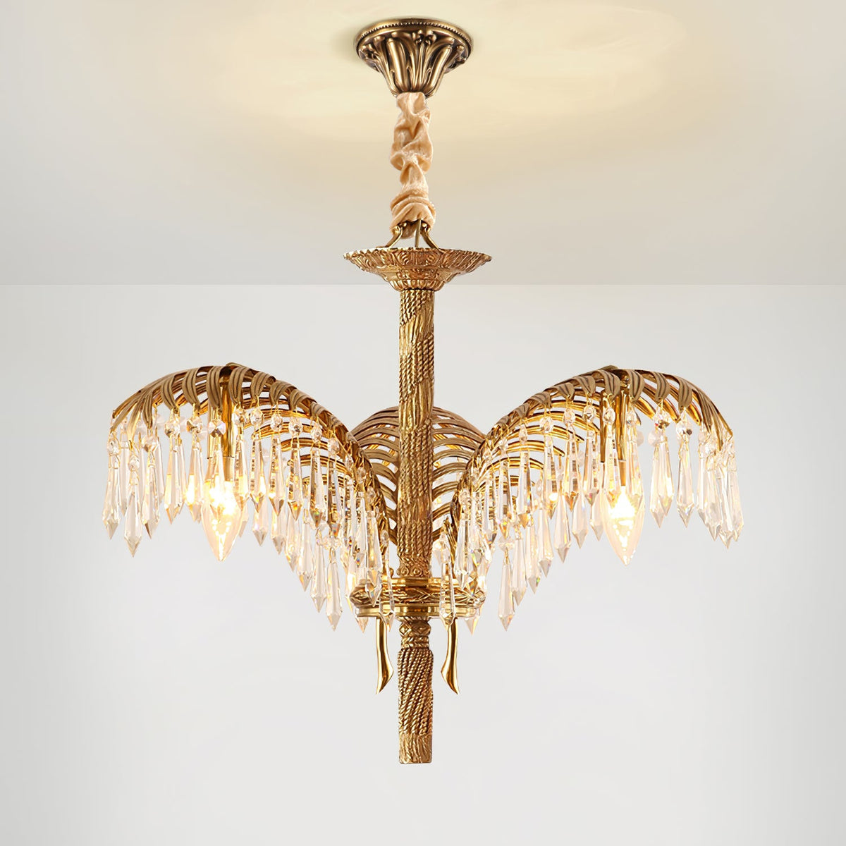 A three-leaf Clérachic chandelier hangs from a bronze ceiling plate with a twisted stem and crystal-fringed leaves.