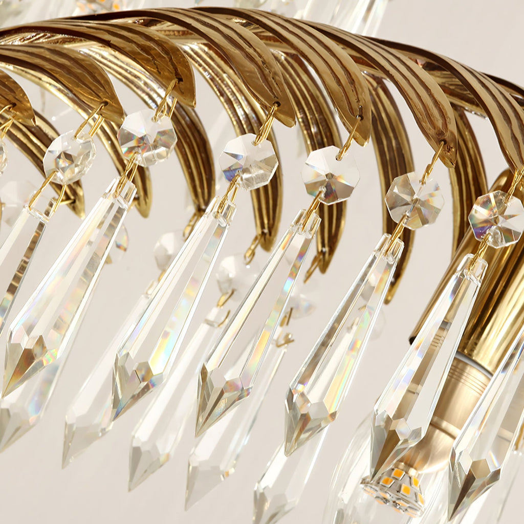 Close view of the ribbed brass leaf underside and the long crystal drops with faceted caps on this Clérachic chandelier.