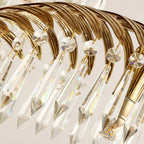 Close view of the ribbed brass leaf underside and the long crystal drops with faceted caps on this Clérachic chandelier.