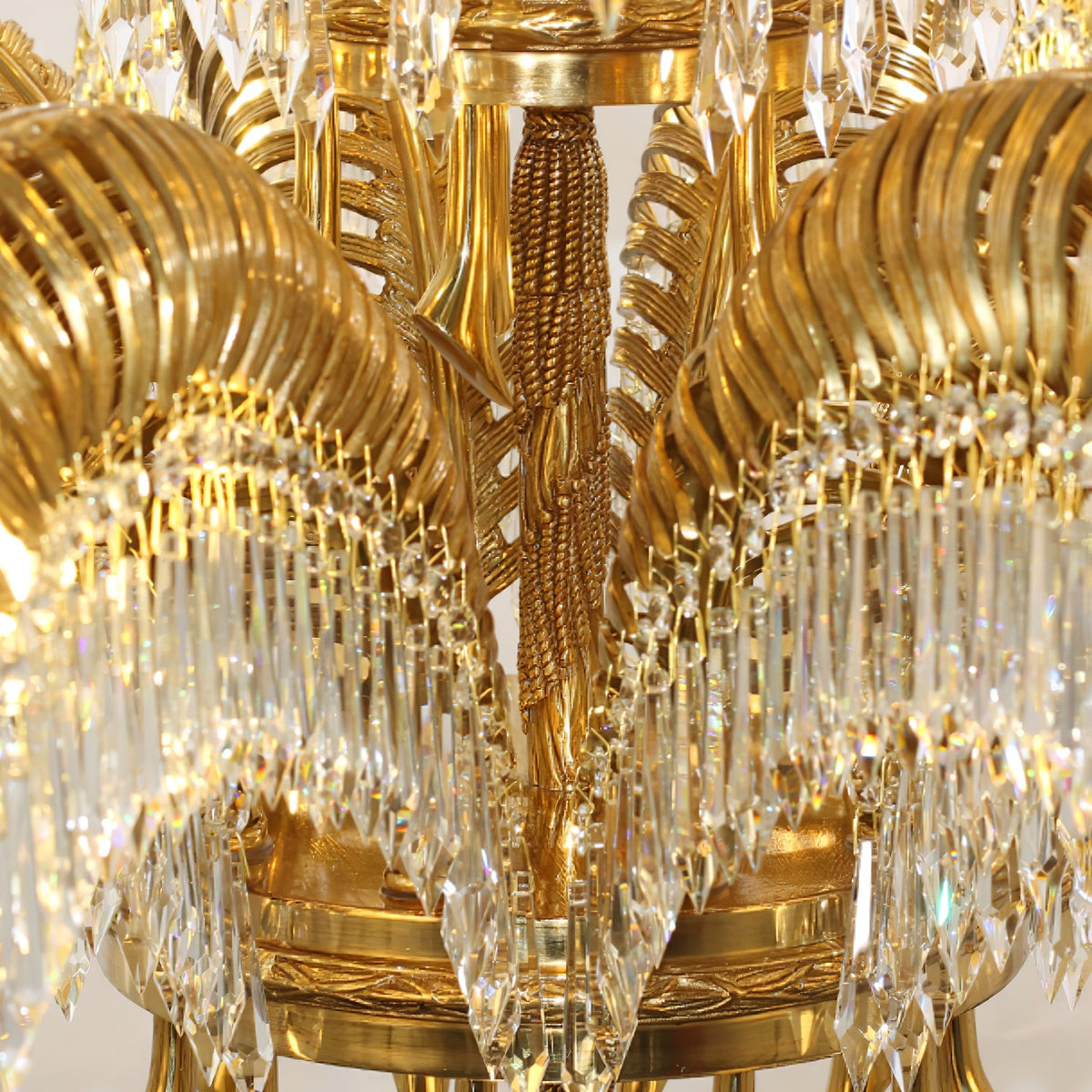 Close view of the carved brass stem and the base ring where the leaves of this Clérachic chandelier meet.