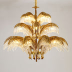 Gold brass Clérachic chandelier in three tiers with crystal drops, on a soft grey backdrop.