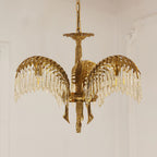 Front view of a three-leaf Clérachic chandelier in brass with crystal fringes, hanging on a chain against a pale wall.