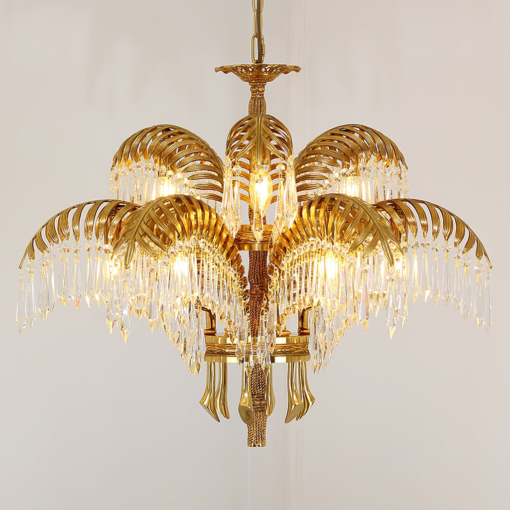 Tiered gold brass Clérachic chandelier with crystal-fringed leaves, photographed on a warm beige backdrop.
