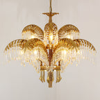 Tiered gold brass Clérachic chandelier with crystal-fringed leaves, photographed on a warm beige backdrop.