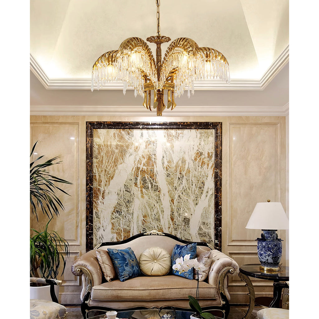 Clérachic chandelier hung from a coved ceiling in a room with a marble feature wall and a carved sofa below.