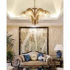 Clérachic chandelier hung from a coved ceiling in a room with a marble feature wall and a carved sofa below.