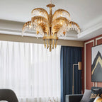 Clérachic chandelier with brass leaves and a gold base hangs in front of sheer curtains and a deep-blue drape.