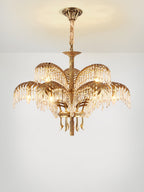 A two-tier Clérachic chandelier with a bronze ceiling plate and cord-wrapped stem, lit warmly on a pale background.