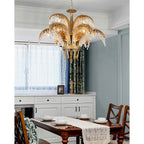 Clérachic brass chandelier over a dining table with a lace runner, in a room with white cabinets and blue-grey walls.