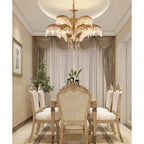 A tiered Clérachic chandelier in a cream dining room with draped curtains and carved, upholstered chairs.