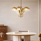 Clérachic gold brass chandelier hanging beside a walnut chest and above a round table with a book and a cup.