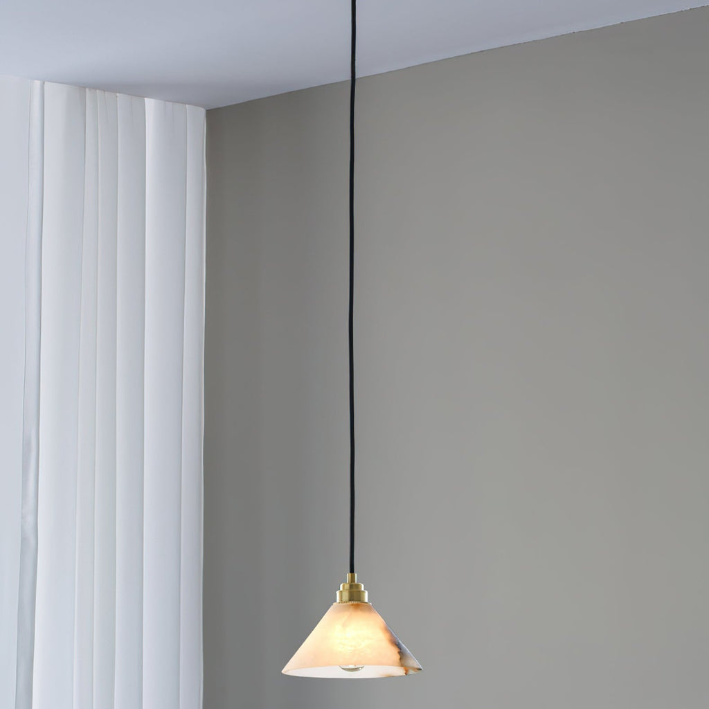 A Clérachic Xen pendant drops from a bedroom ceiling corner beside sheer curtains and a muted grey accent wall.