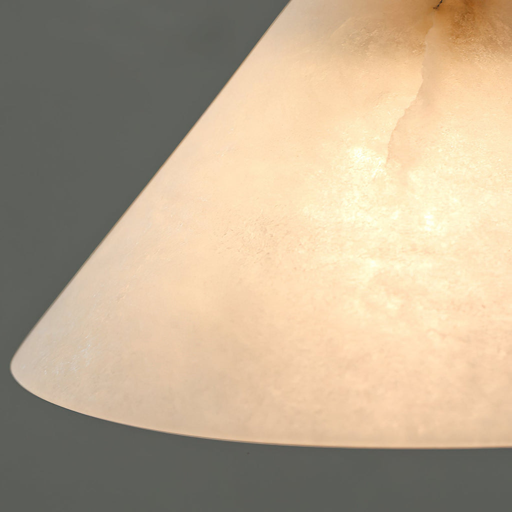 Underside macro of the Clérachic Xen pendant's alabaster shade rim, showing the stone's soft grain from below.