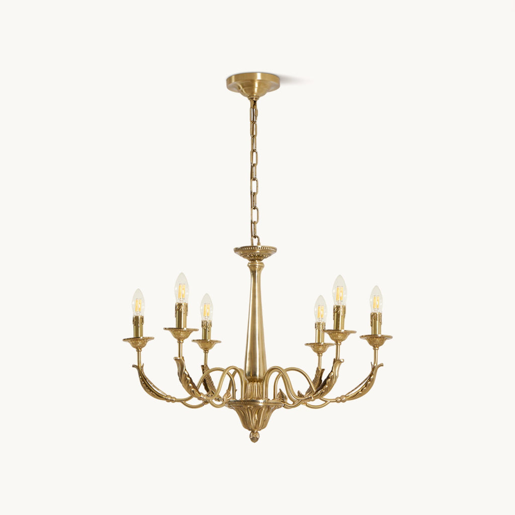 A brass candle-style Clérachic chandelier with six arms, a tapered column and a hanging chain, on a plain white backdrop.