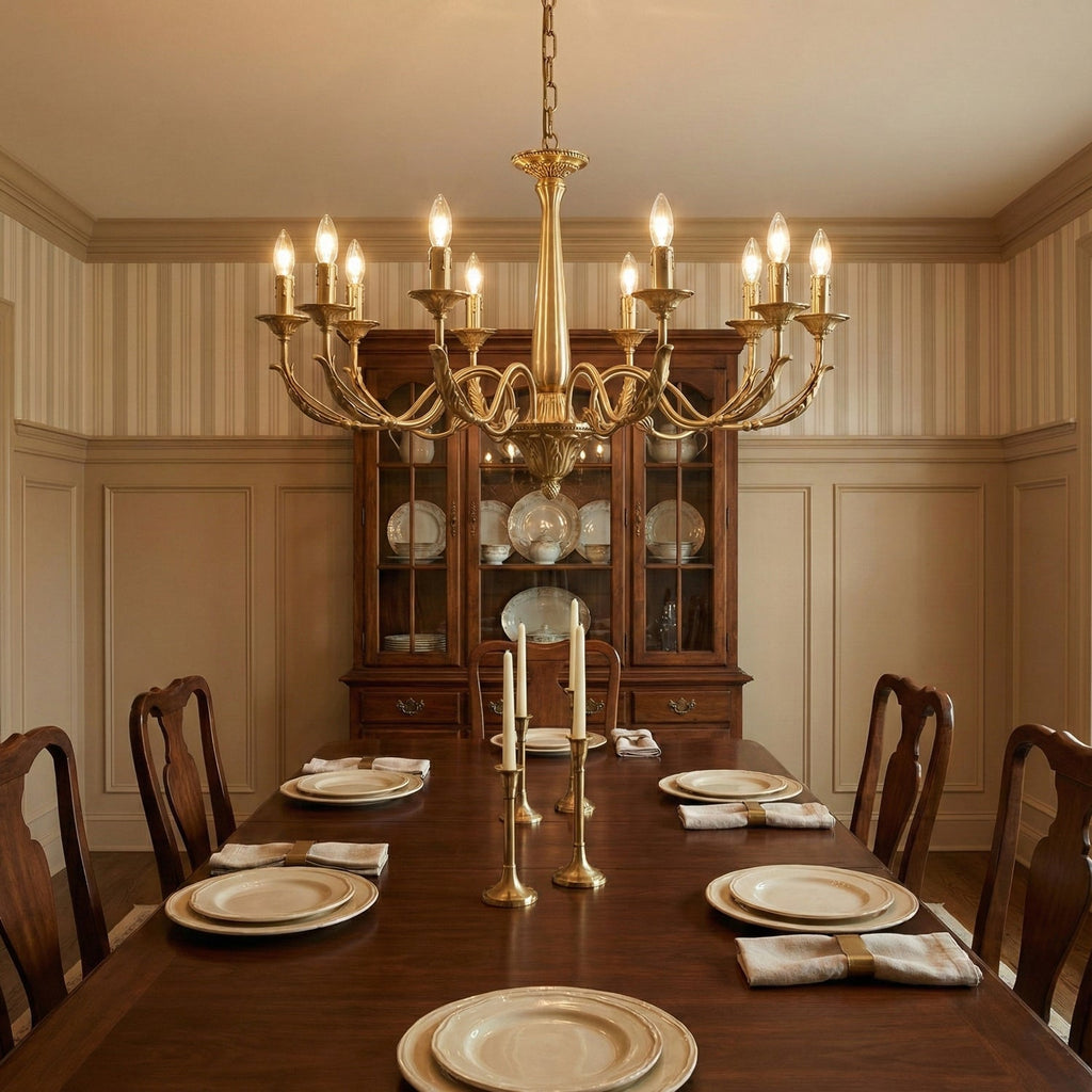 A brass candle-style Clérachic chandelier above a long wooden dining table laid with plates, in a panelled dining room.