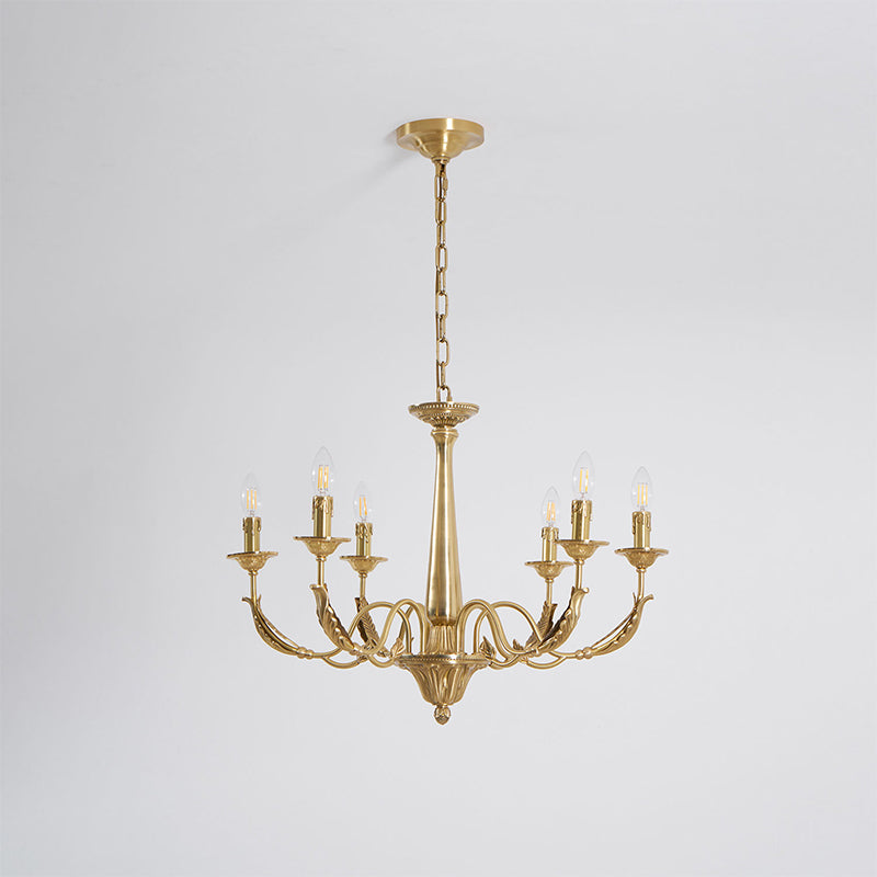 Hung from a chain and a ceiling canopy on a pale backdrop, this six-arm brass candle-style Clérachic chandelier is unlit.
