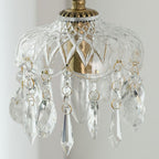 Close view of the brass collar, the diamond-cut glass bowl and the faceted crystal drops on this Clérachic pendant.
