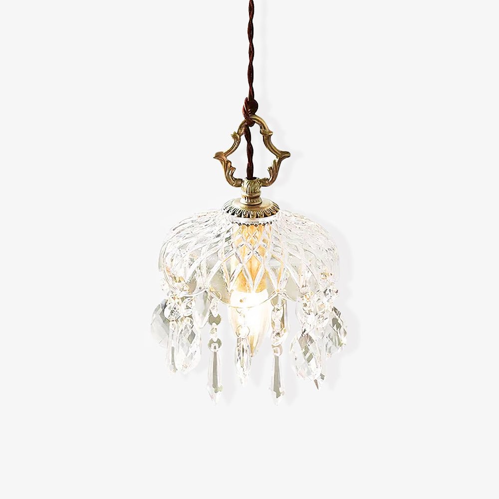 Clérachic crystal-drop pendant on a pale backdrop, with a brass crown finial and a dark twisted cord, with the glass bowl barely lit.