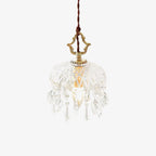 Clérachic crystal-drop pendant in a sunlit room, with a yellow chair, a white round table and shadows of window frames on the wall.