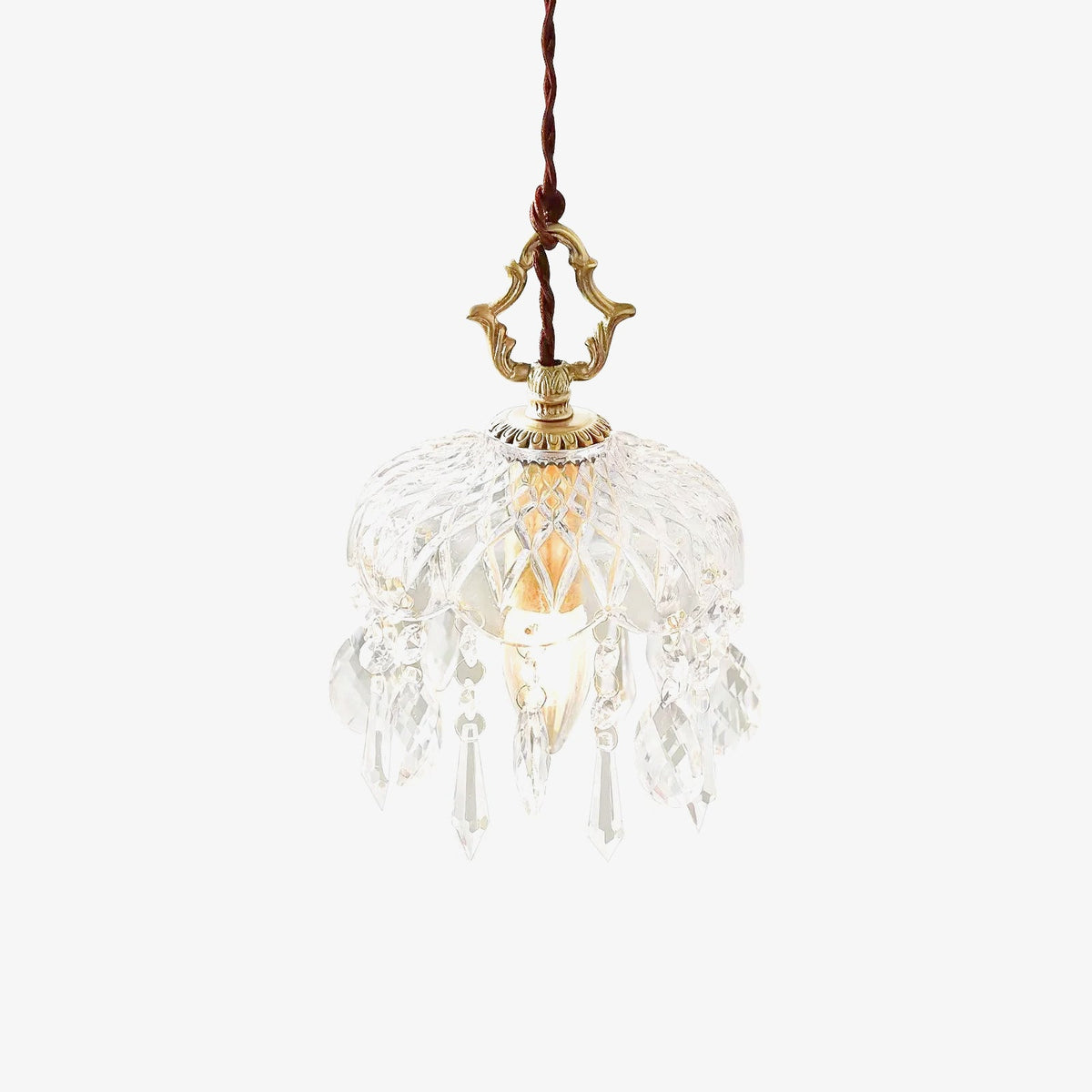 Clérachic crystal-drop pendant in a sunlit room, with a yellow chair, a white round table and shadows of window frames on the wall.