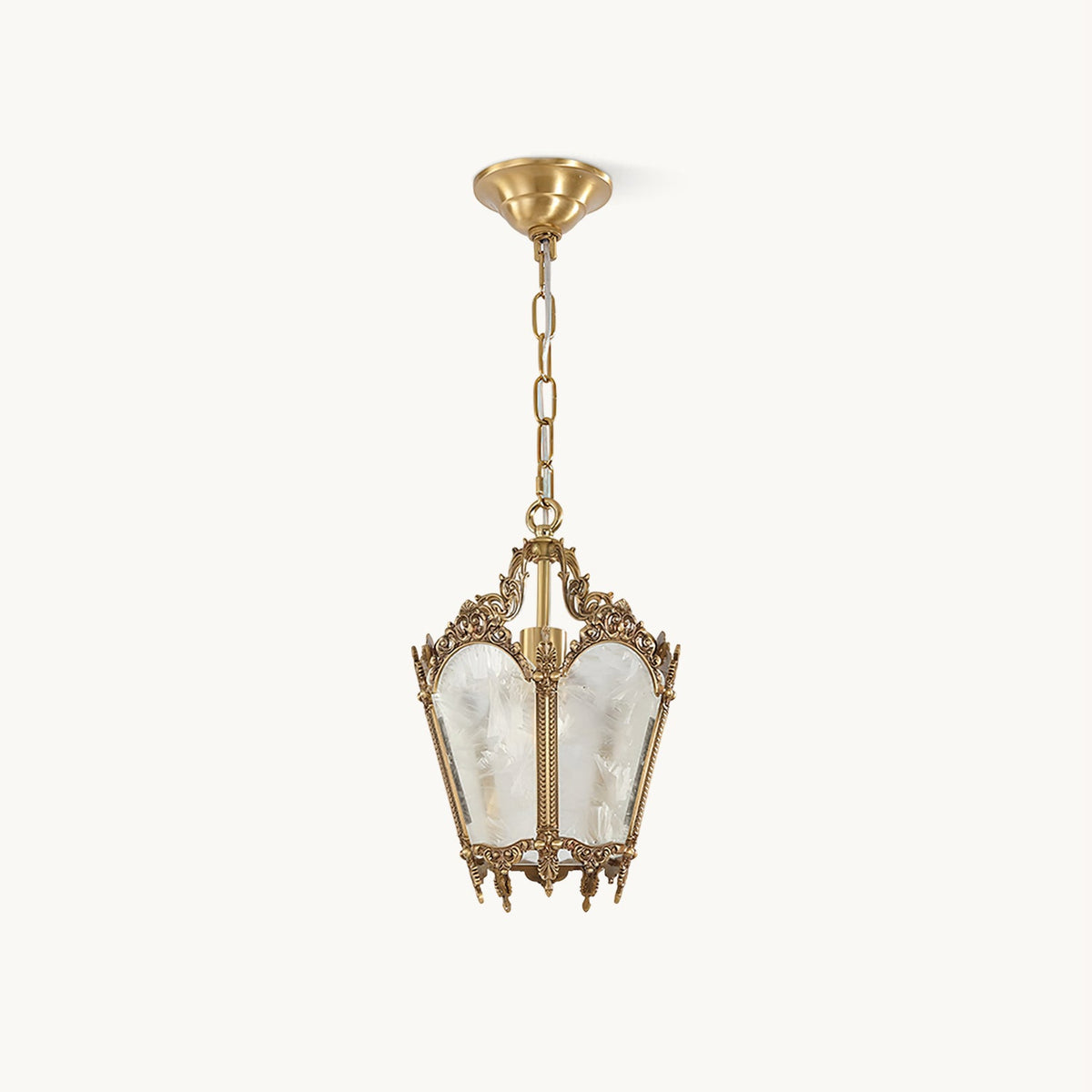On a plain white backdrop, a Clérachic lantern pendant with an ornate brass frame, frosted glass panels and a slim hanging chain.