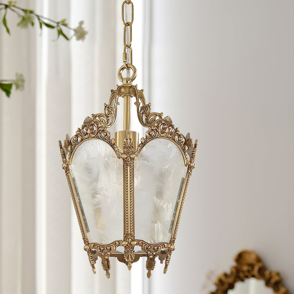 Close view of a Clérachic lantern pendant with an ornate brass crown and frosted glass, hanging by sheer white curtains.
