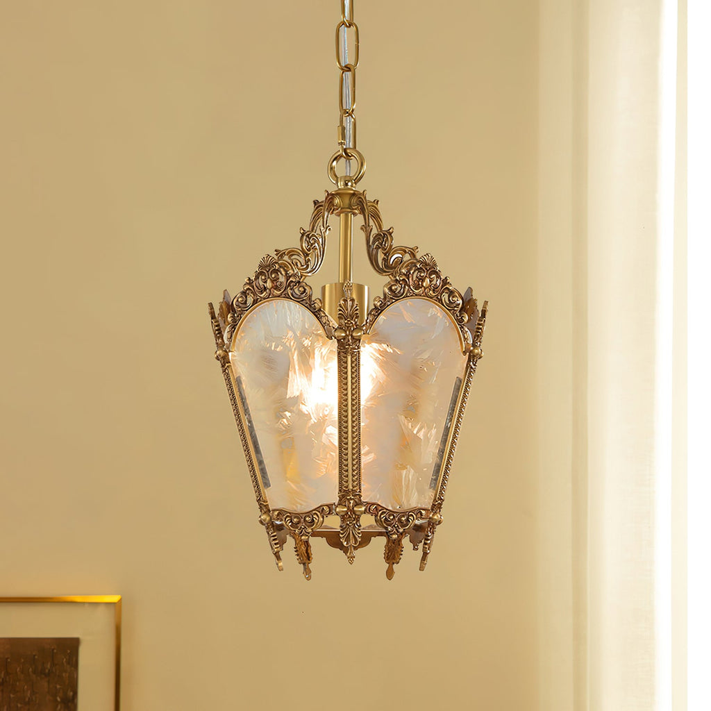 Another view of this Clérachic lantern pendant against a cream wall and curtain, its brass scrolls catching the warm light.