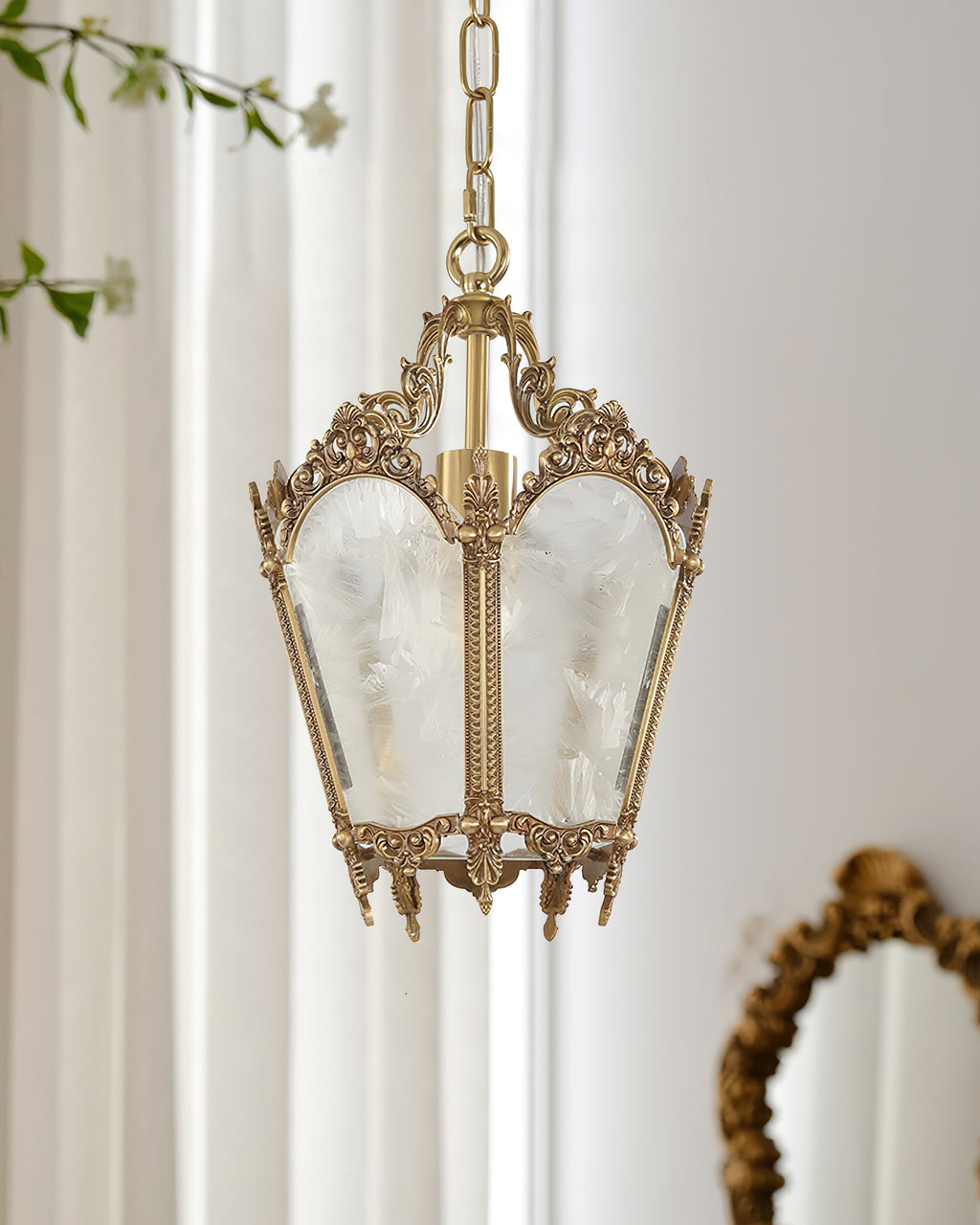 A Clérachic lantern pendant hangs in front of sheer curtains, with the edge of a gilt oval mirror at the lower right.