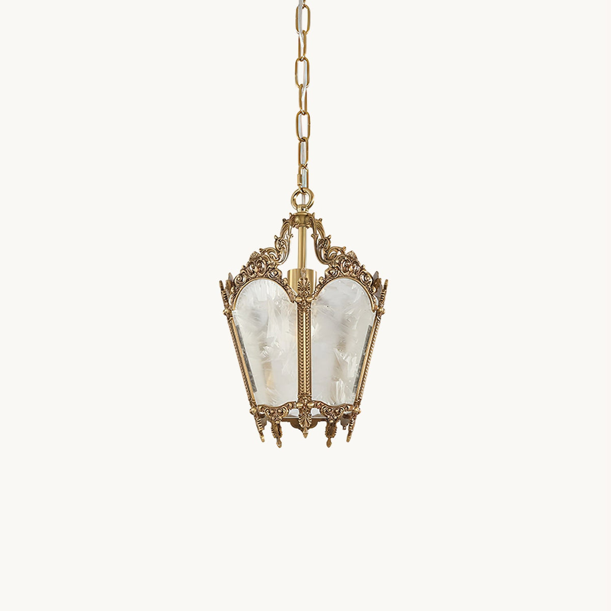 A small Clérachic lantern pendant with an ornate brass top, frosted panels and a thin chain, hanging on a pale cream backdrop.