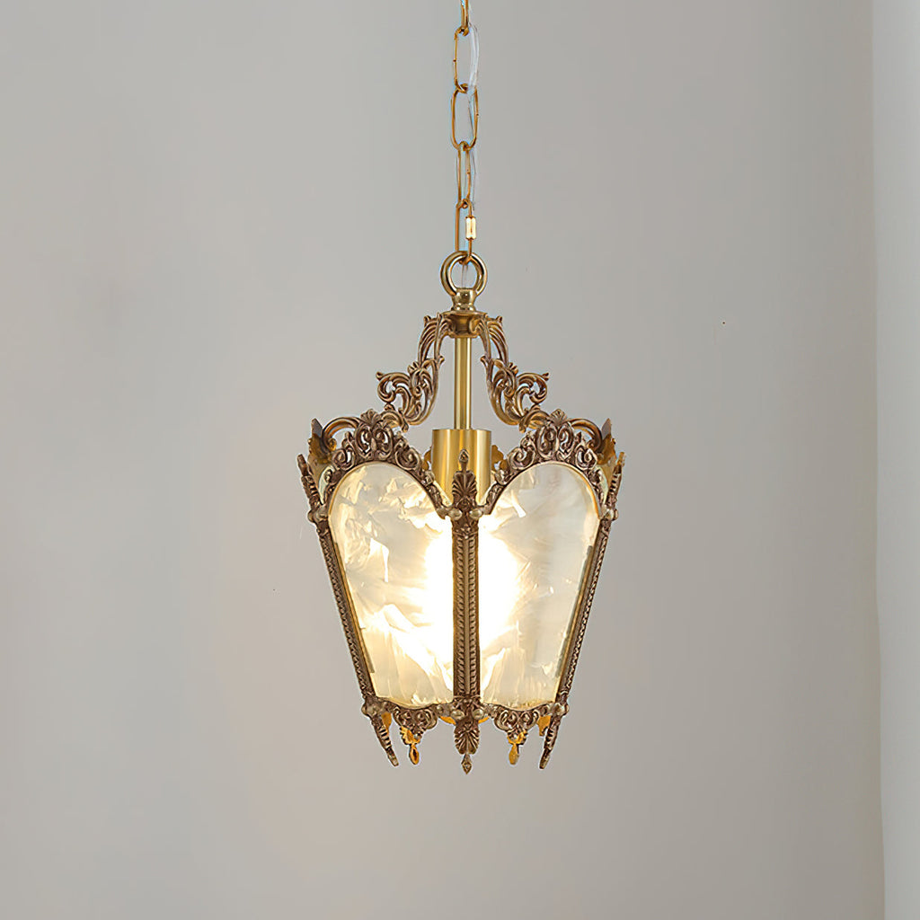 A lit Clérachic lantern pendant on a pale grey backdrop, its frosted panels glowing and its brass crown finely detailed.