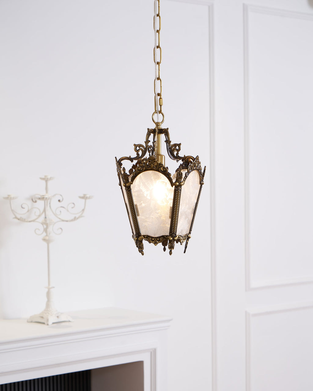 A lit Clérachic lantern pendant hangs beside a white candelabra and a panelled wall, with a mantel below.