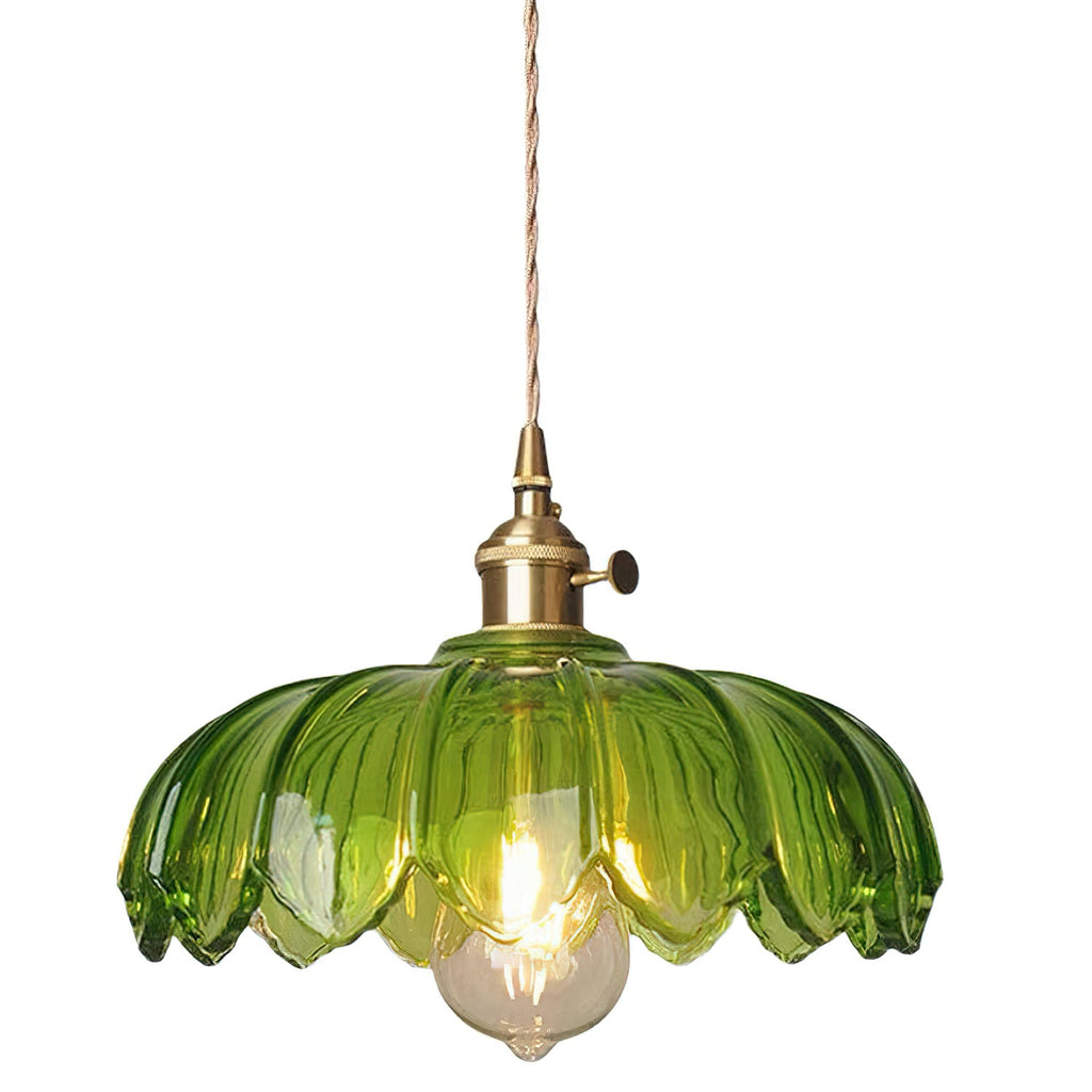 Green glass Clérachic pendant with a petal-edged shade, a brass fitting and a lit bulb, on a plain white backdrop.