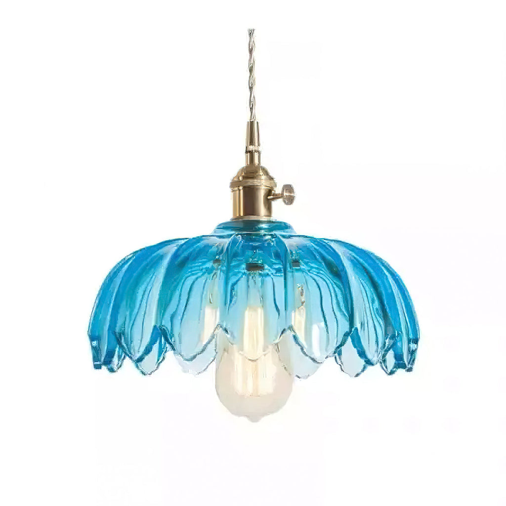 Blue glass Clérachic pendant with a petal-edged shade, a brass switch fitting and a warm bulb, on a plain white backdrop.